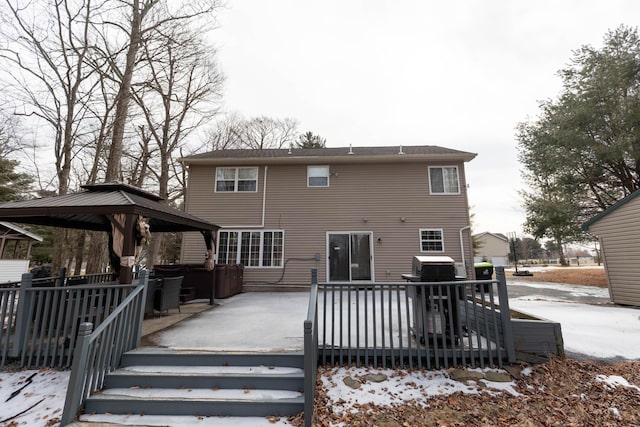 snow covered house with a wooden deck and a gazebo