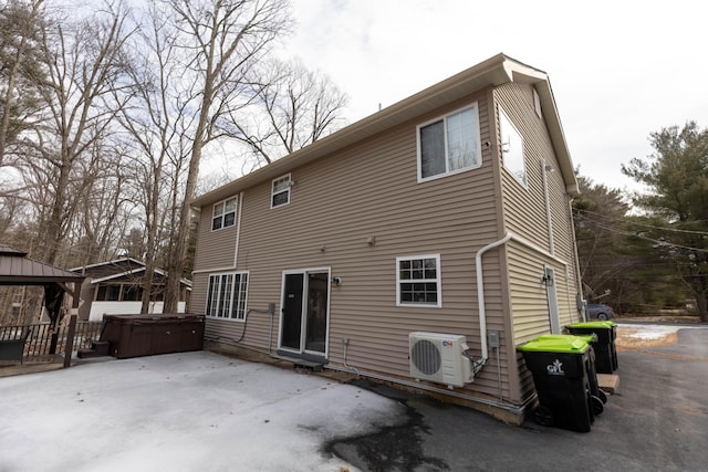 back of property with ac unit, a hot tub, a patio, and a gazebo