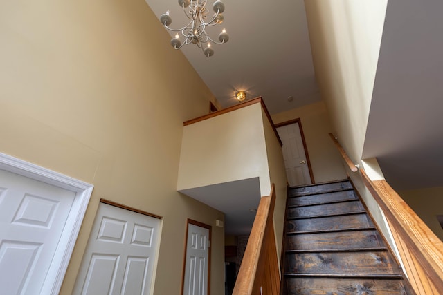 stairway featuring a chandelier and a high ceiling