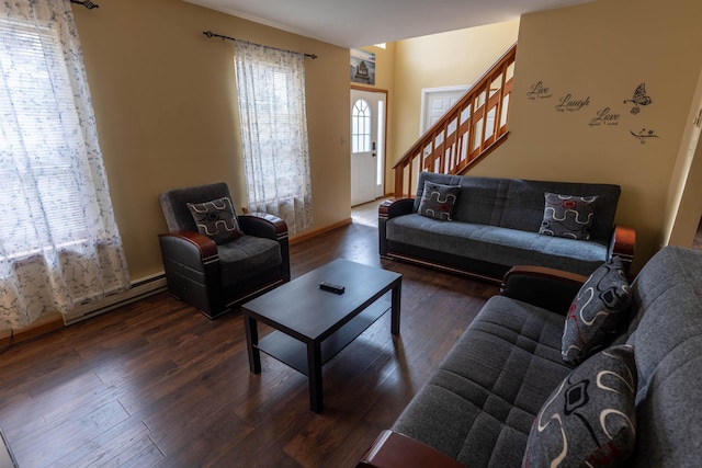 living room featuring a baseboard heating unit, stairway, and wood finished floors