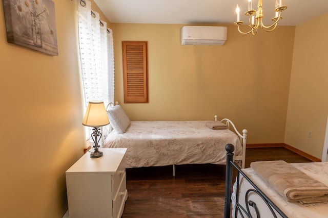 bedroom with a wall unit AC, an inviting chandelier, baseboards, and dark wood-style flooring