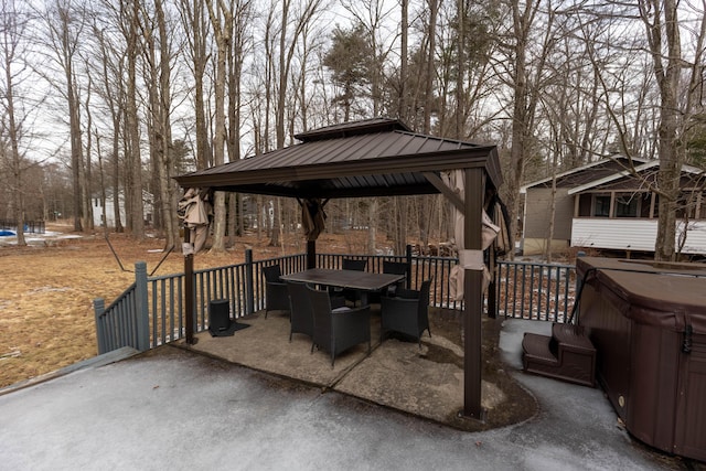 view of patio featuring outdoor dining space, a hot tub, and a gazebo