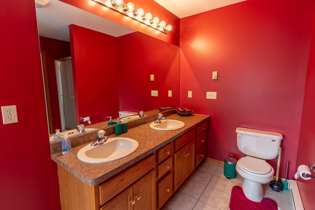 bathroom featuring toilet, tile patterned flooring, a baseboard radiator, and a sink