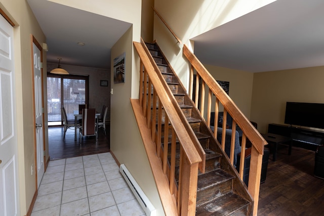 stairway featuring a baseboard radiator, tile patterned flooring, and baseboards