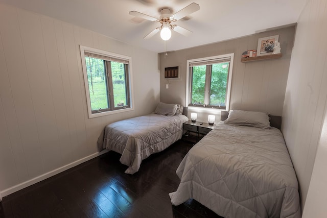 bedroom with dark wood finished floors, baseboards, and ceiling fan