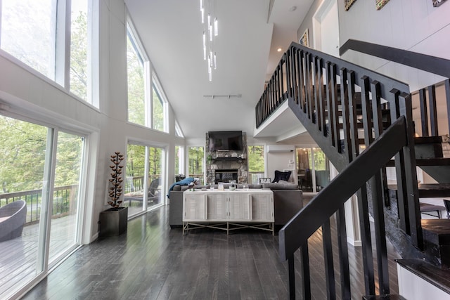 living area featuring a high ceiling, dark wood-style floors, and a fireplace