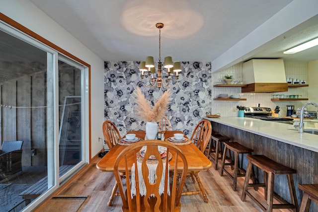 dining room featuring baseboards, a chandelier, and light wood finished floors