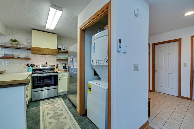 kitchen with open shelves, custom exhaust hood, stainless steel appliances, stacked washer / dryer, and backsplash