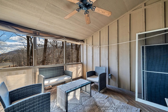 unfurnished sunroom featuring lofted ceiling, wood ceiling, and a ceiling fan