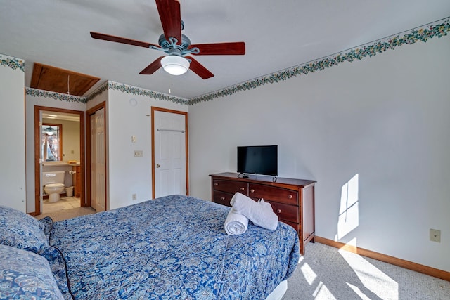 carpeted bedroom with baseboards, ensuite bath, attic access, and ceiling fan