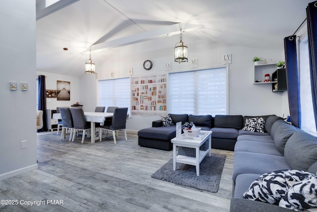 living room with visible vents, vaulted ceiling, an inviting chandelier, and wood finished floors