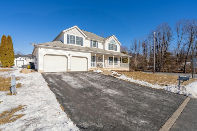 view of front facade featuring a porch, a garage, and aphalt driveway