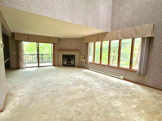 402 Shinymountain Ct, Greentown, PA 18426 - unfurnished living room featuring baseboard heating, carpet flooring, plenty of natural light, and a tile fireplace