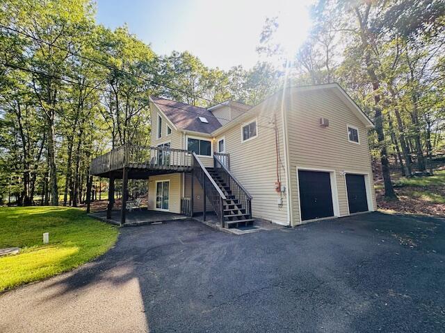 2383 Eagle Path, Bushkill, PA 18324 - view of front of property with a wooden deck, stairs, a garage, asphalt driveway, and a front yard