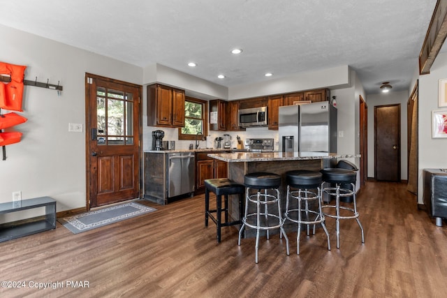 156 Poplar Pl, Blakeslee, PA 18610 - kitchen with stainless steel appliances, a breakfast bar, dark wood-style flooring, and light stone counters
