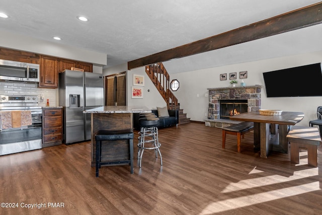156 Poplar Pl, Blakeslee, PA 18610 - kitchen featuring dark wood finished floors, decorative backsplash, a kitchen island, appliances with stainless steel finishes, and a kitchen bar