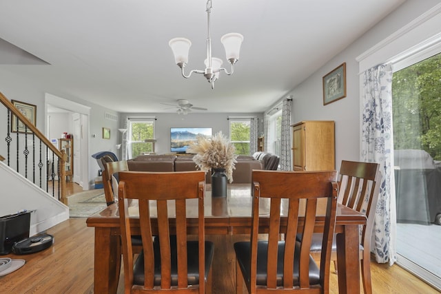 1127 Fillmore St, East Stroudsburg, PA 18301 - dining area with light wood-type flooring, a ceiling fan, stairs, and a chandelier