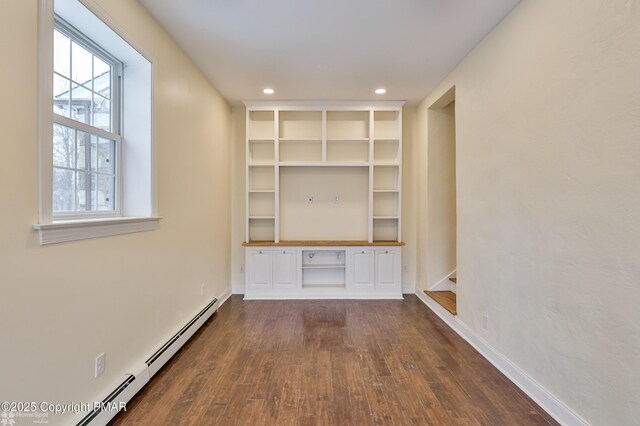 corridor with baseboard heating, dark wood-type flooring, baseboards, and recessed lighting