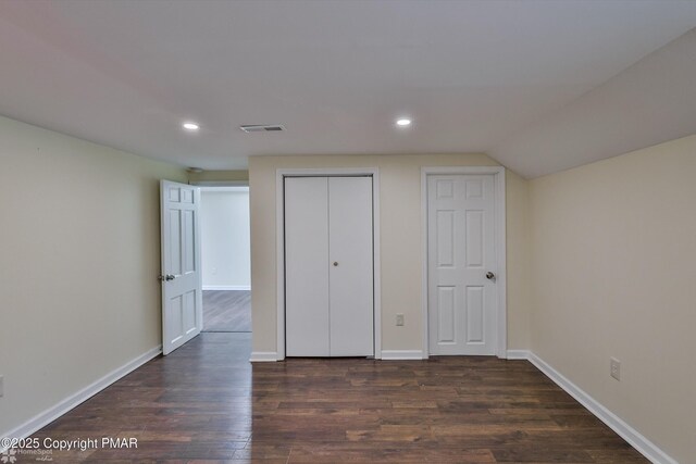unfurnished bedroom with recessed lighting, dark wood-type flooring, baseboards, and a closet