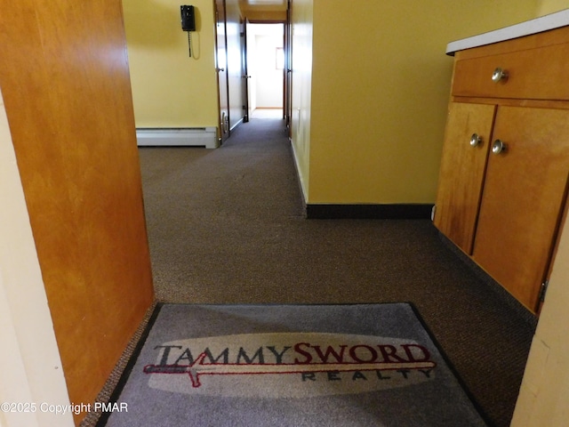 hall featuring baseboards, baseboard heating, and carpet flooring