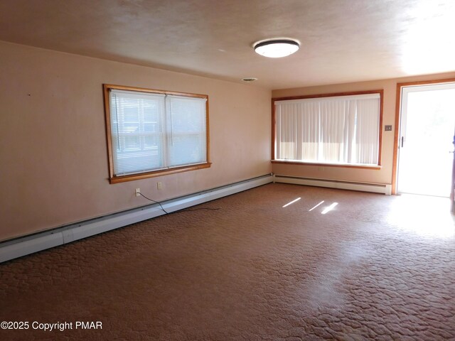 spare room featuring carpet and a baseboard heating unit