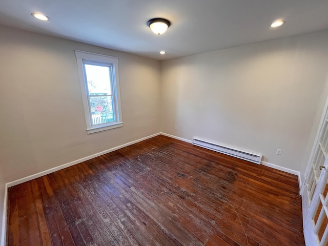 empty room featuring a baseboard heating unit, hardwood / wood-style flooring, recessed lighting, and baseboards