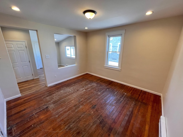 unfurnished room with recessed lighting, baseboards, baseboard heating, and dark wood finished floors