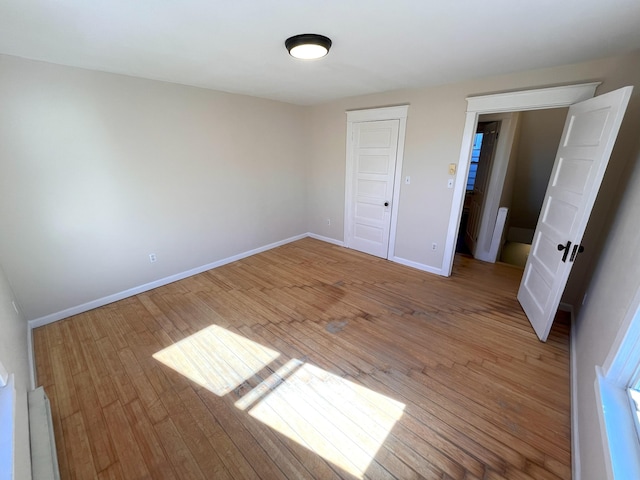 unfurnished bedroom featuring light wood-style flooring and baseboards