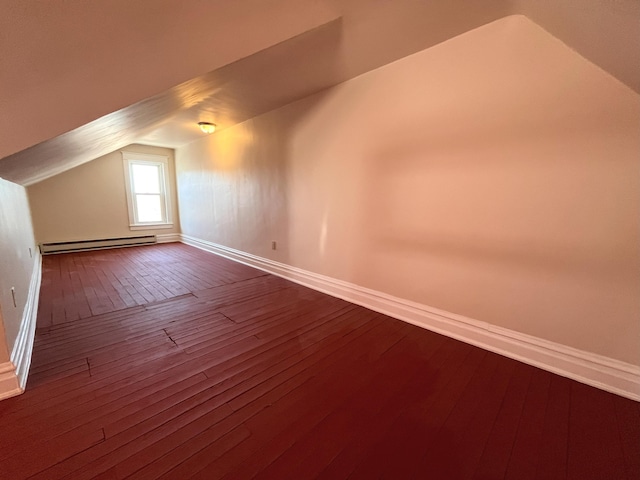 bonus room with baseboard heating, dark wood-style flooring, and vaulted ceiling