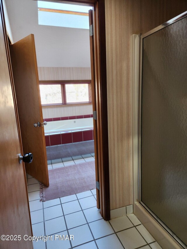 bathroom with a healthy amount of sunlight, tile patterned flooring, and plus walk in shower