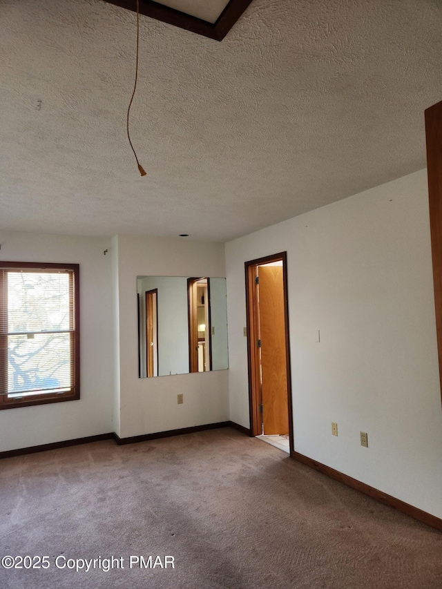 spare room with a textured ceiling and carpet flooring