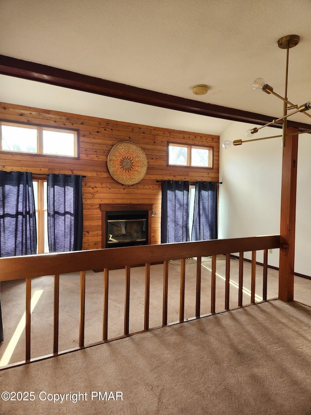 stairs featuring wood walls, carpet floors, beam ceiling, and a healthy amount of sunlight