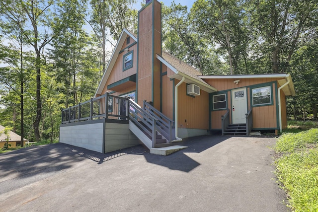 3109 Snowden Dr, Bushkill, PA 18324 - chalet / cabin featuring a chimney, entry steps, a shingled roof, and a wall mounted air conditioner