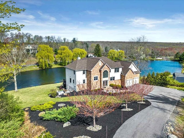 301 Reagan Dr, East Stroudsburg, PA 18301 - view of front facade with a garage, a water view, driveway, and stone siding