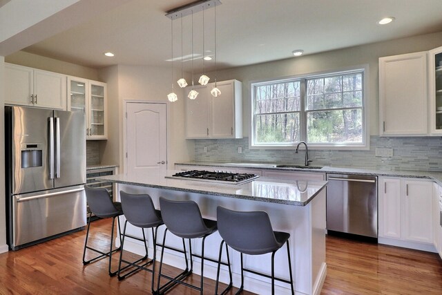 301 Reagan Dr, East Stroudsburg, PA 18301 - kitchen with decorative backsplash, a kitchen island, light stone countertops, a sink, and stainless steel appliances