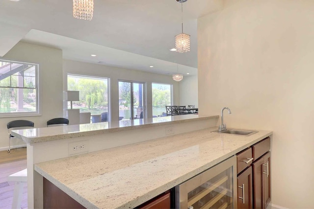301 Reagan Dr, East Stroudsburg, PA 18301 - interior space featuring decorative light fixtures, a sink, light stone counters, baseboards, and beverage cooler