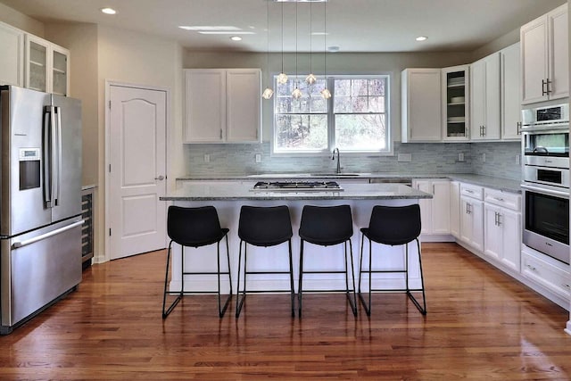 301 Reagan Dr, East Stroudsburg, PA 18301 - kitchen featuring glass insert cabinets, a kitchen breakfast bar, a sink, backsplash, and stainless steel appliances