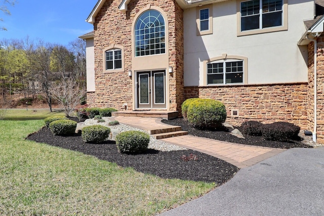 301 Reagan Dr, East Stroudsburg, PA 18301 - entrance to property with french doors, stucco siding, a yard, and stone siding