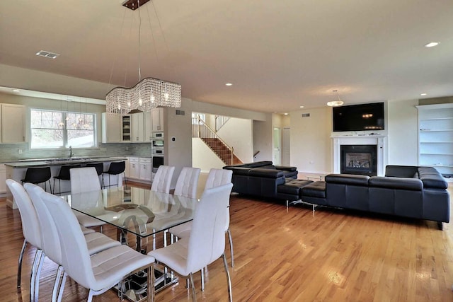301 Reagan Dr, East Stroudsburg, PA 18301 - dining room featuring visible vents, stairs, a fireplace, light wood-style floors, and recessed lighting