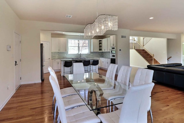 301 Reagan Dr, East Stroudsburg, PA 18301 - dining area with stairs, baseboards, a chandelier, and light wood-type flooring