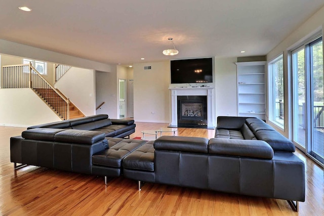 301 Reagan Dr, East Stroudsburg, PA 18301 - living room with stairs, visible vents, a glass covered fireplace, and light wood finished floors