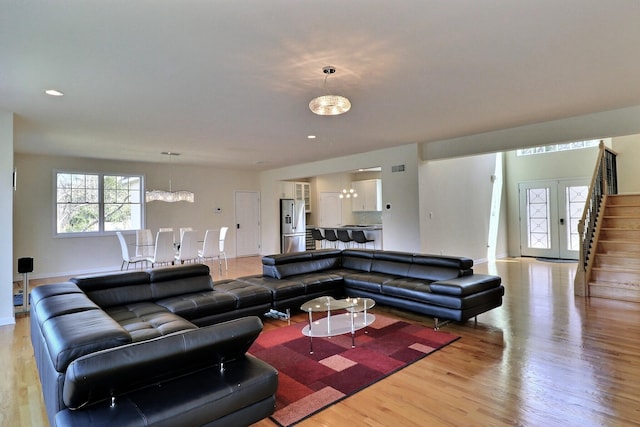 301 Reagan Dr, East Stroudsburg, PA 18301 - living room with visible vents, light wood-type flooring, baseboards, a notable chandelier, and stairs