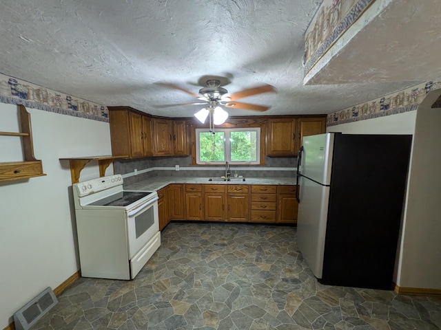 124 Sterling Valley Rd, Kunkletown, PA 18058 - kitchen featuring electric range, freestanding refrigerator, a ceiling fan, brown cabinetry, and dark stone finish flooring