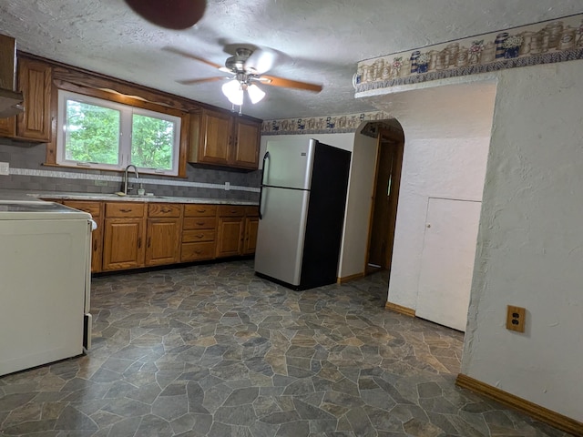 124 Sterling Valley Rd, Kunkletown, PA 18058 - kitchen with freestanding refrigerator, stove, stone floors, brown cabinetry, and a ceiling fan