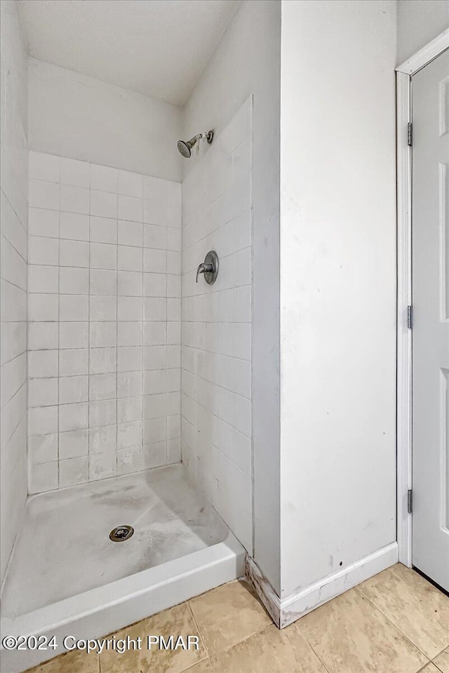 bathroom with a stall shower and tile patterned flooring