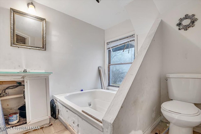 bathroom with a jetted tub, vanity, toilet, and tile patterned floors