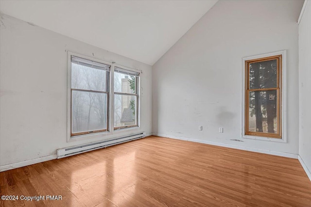 unfurnished room with a baseboard heating unit, high vaulted ceiling, wood finished floors, and baseboards