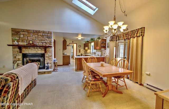 dining room featuring a baseboard heating unit, light colored carpet, a stone fireplace, and an inviting chandelier