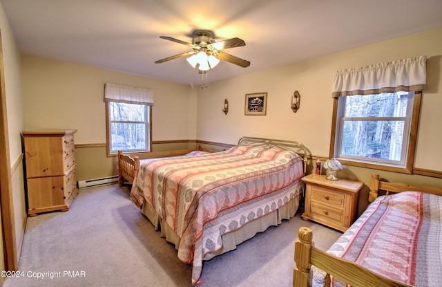 bedroom with a ceiling fan, light carpet, and baseboard heating