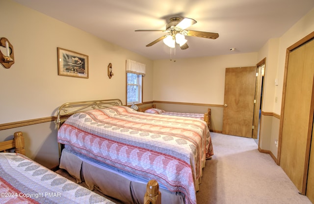 bedroom with ceiling fan, baseboards, a closet, and light colored carpet